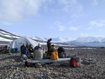 Blick auf Lagerfeuer und Gemeinschaftszelt
